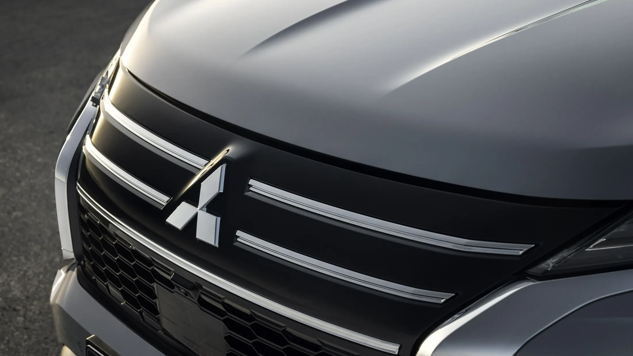 Mitsubishi Outlander PHEV MY2025 in woestijn met wolkenlucht