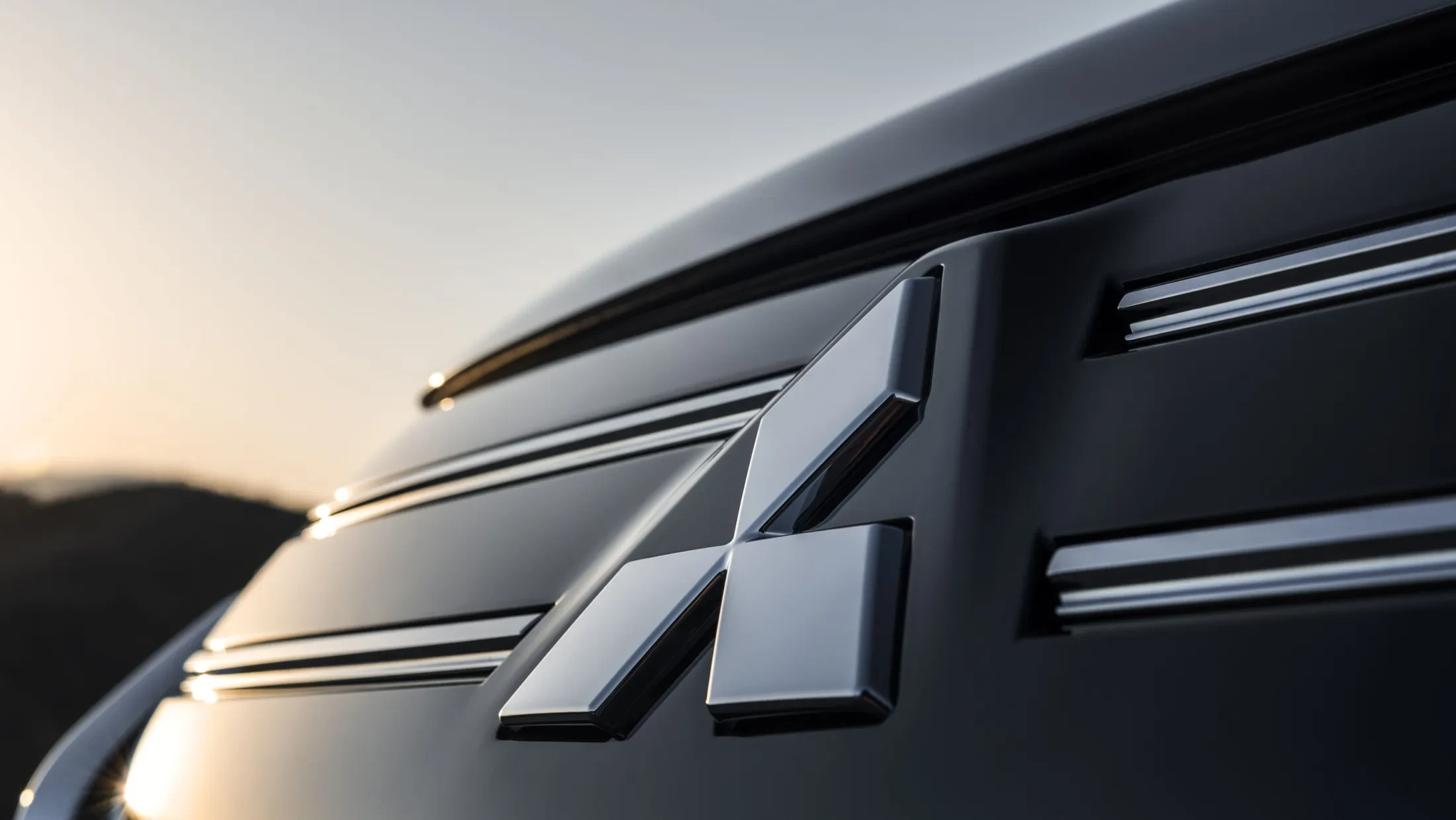 Mitsubishi Outlander PHEV MY2025 in woestijn met wolkenlucht