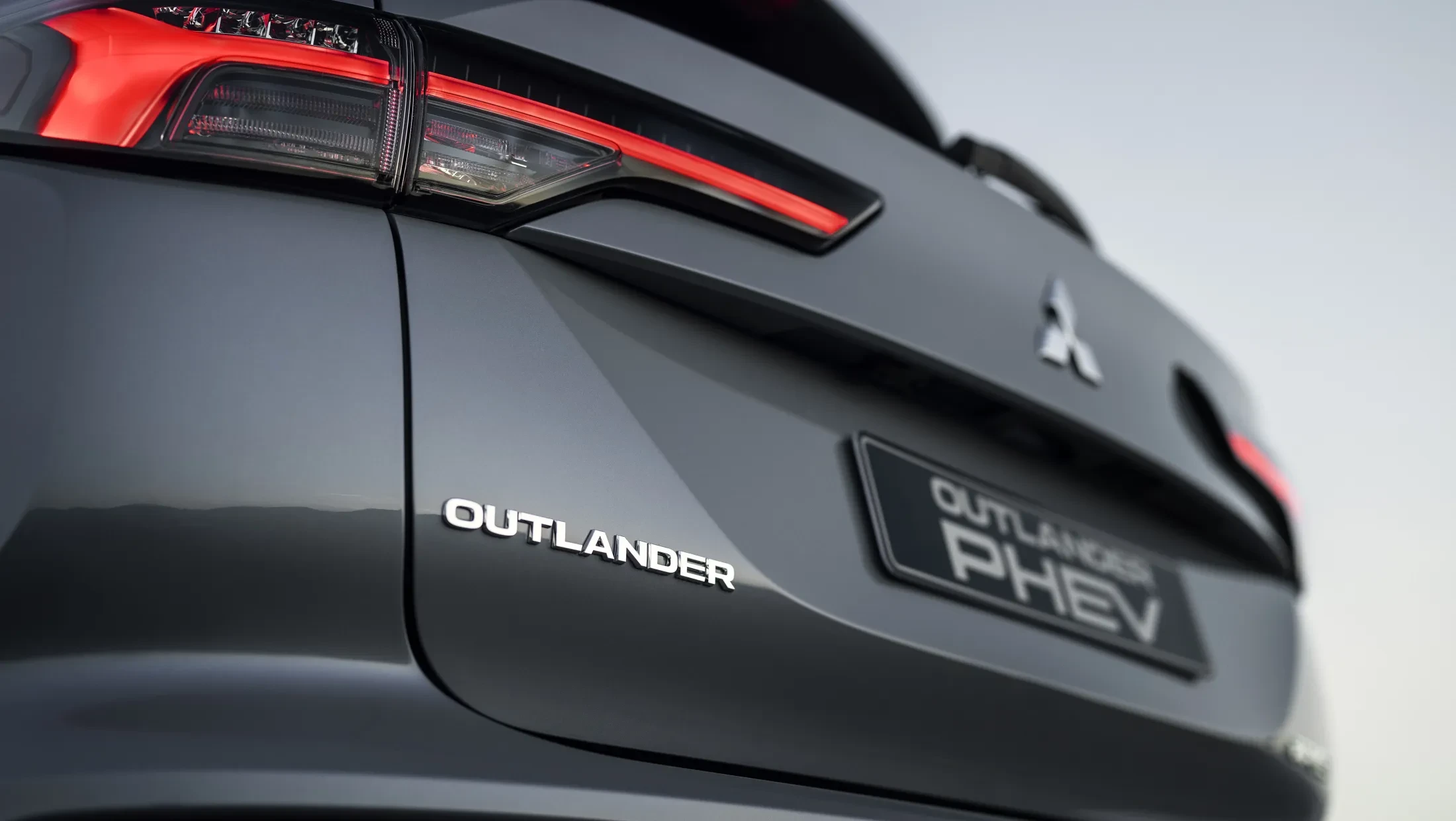 Mitsubishi Outlander PHEV MY2025 in woestijn met wolkenlucht