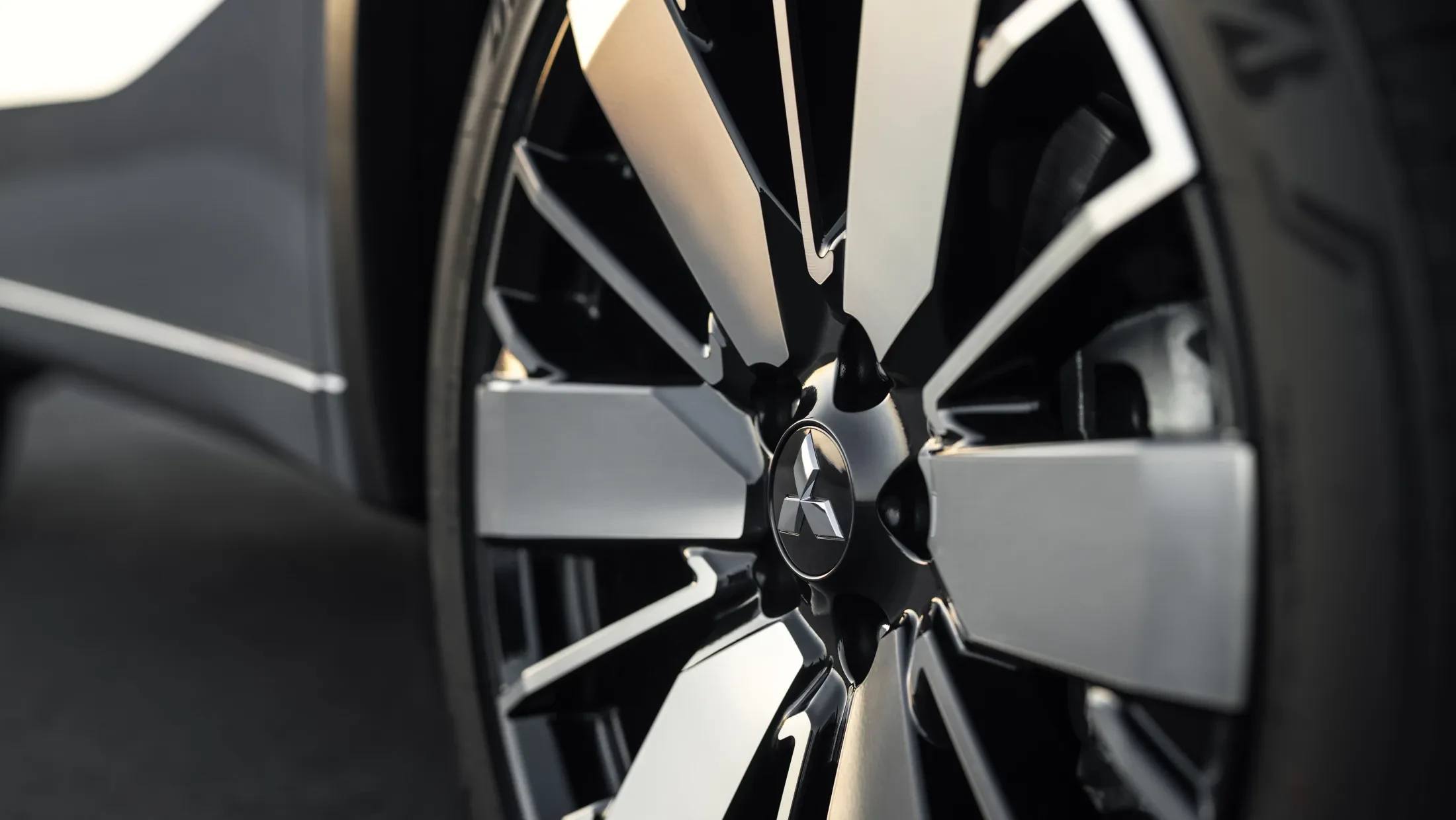 Mitsubishi Outlander PHEV MY2025 in woestijn met wolkenlucht