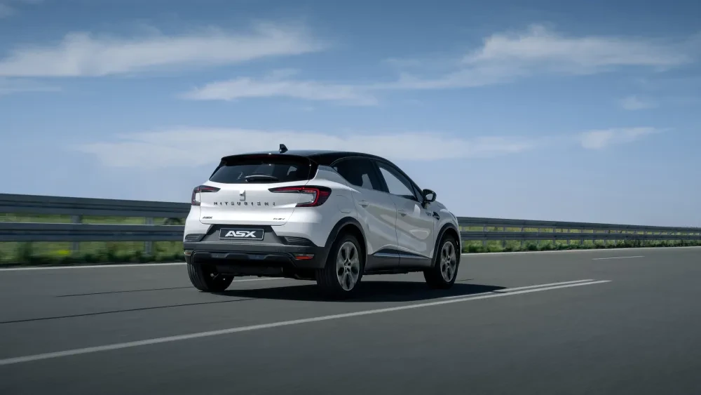 achterkan Witte Mitsubishi ASX MY2023 op snelweg met op de achtergrond een blauwe lucht met wolken